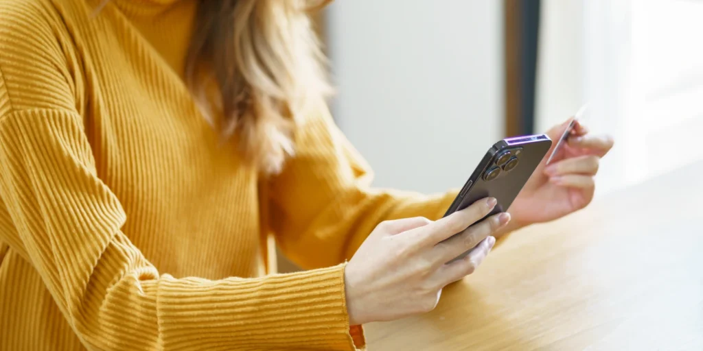 Primer plano de una persona haciendo una compra a través del móvil en un ecommerce